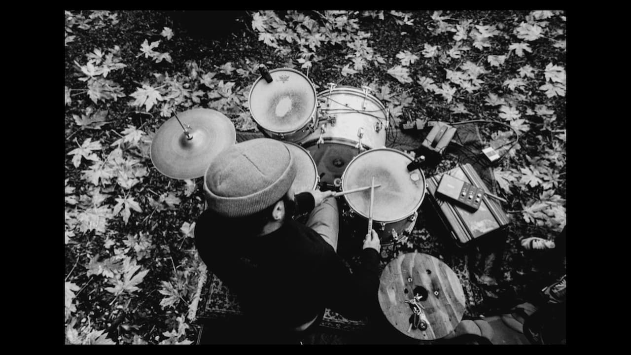 A black-and-white overhead shot of John at the kit with leaves on the ground.
