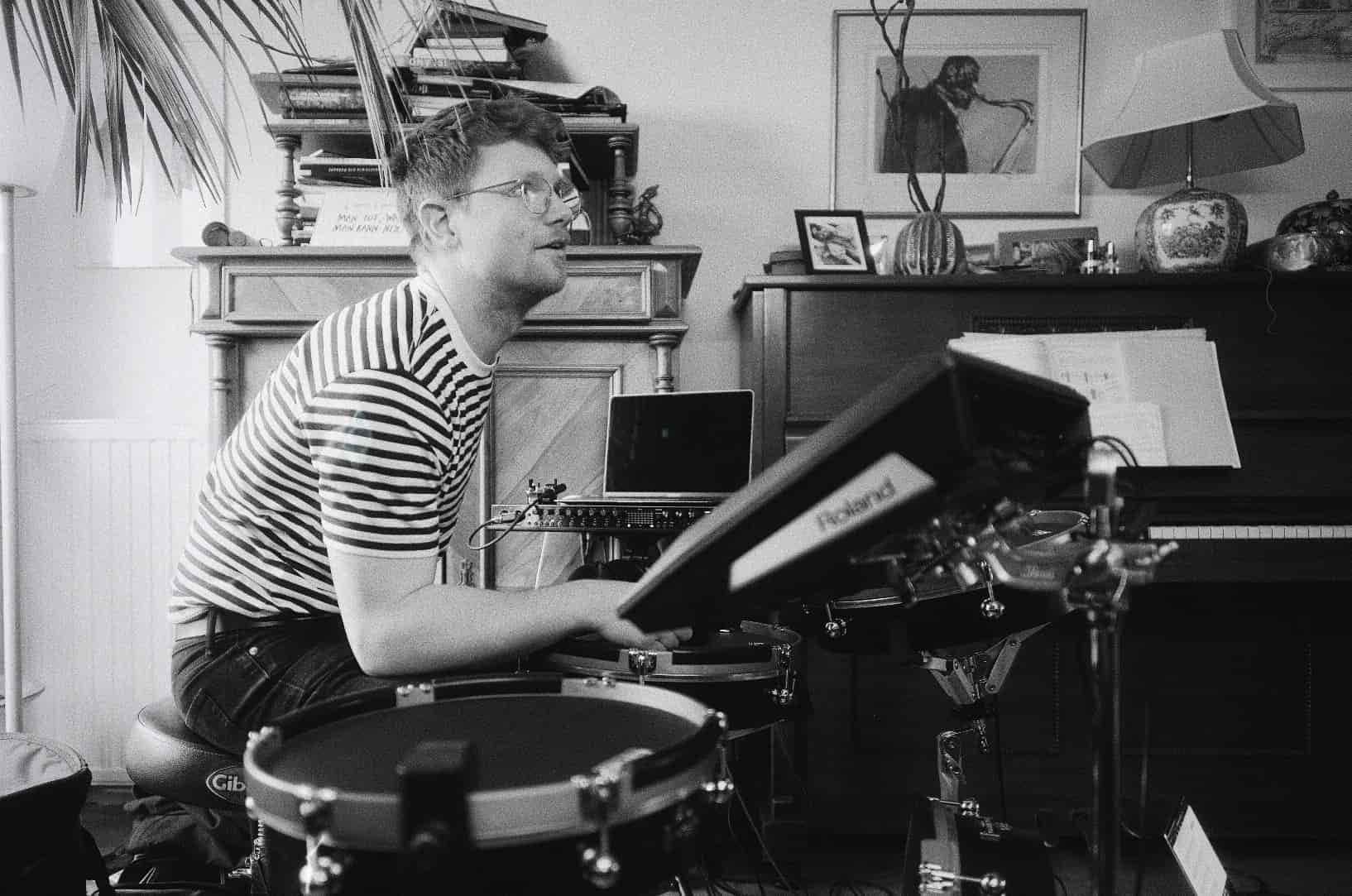 A black-and-white photo of Karl behind the kit.