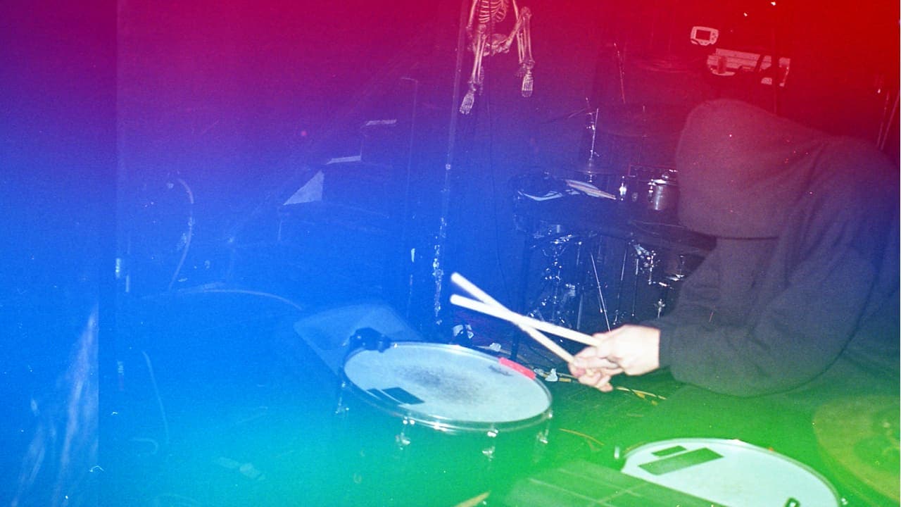 A photo of Michul Kuun wearing a black hoodie playing a drumset with Sensory Percussion