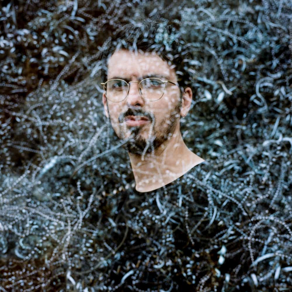 Antoine Pierre looking at the camera with a reflection of a wintery scene overlaying his face