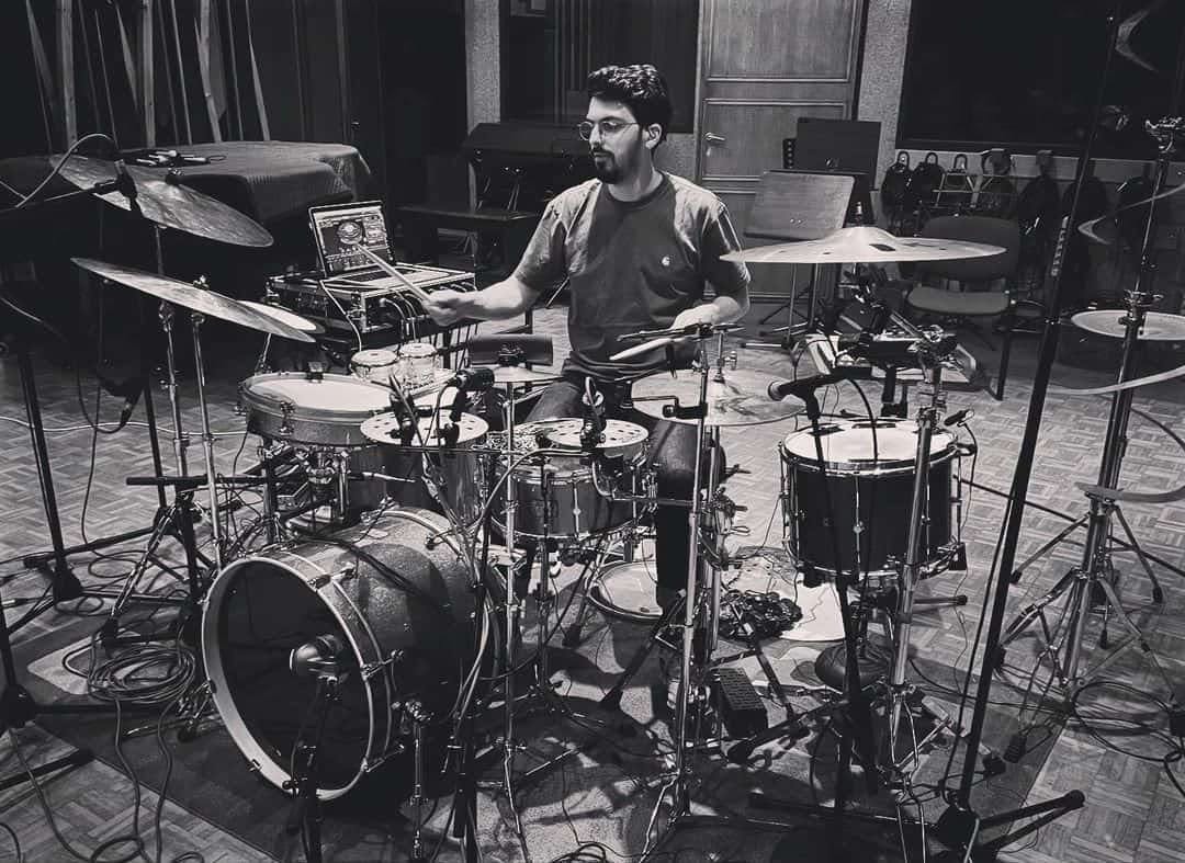 A black and white photo of Antoine Pierre in the studio with a hybrid kit using Sensory Percussion with mesh heads and acoustic drums