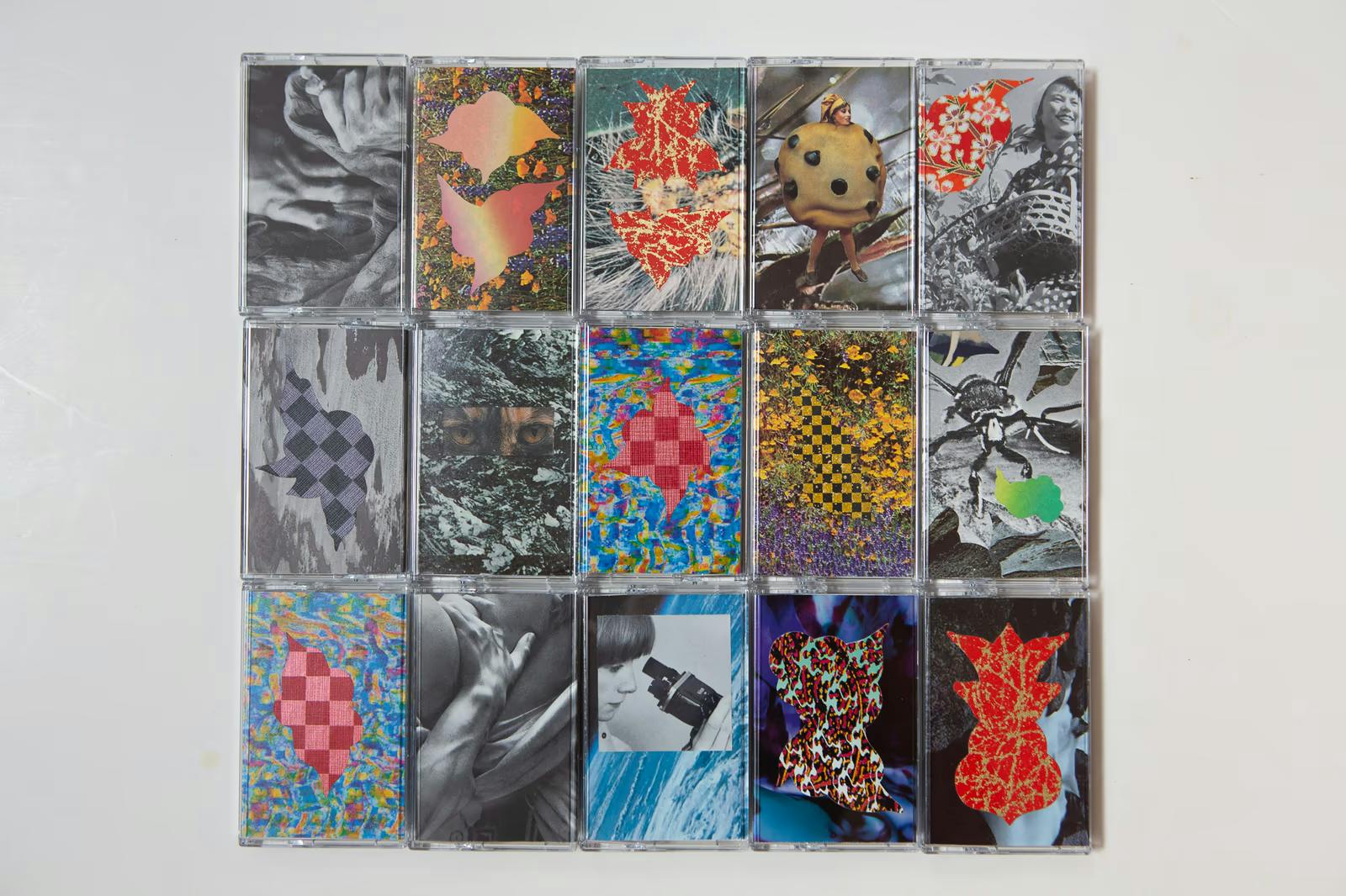 A photo of 15 cassettes, ech with different artwork on the cover, lined up in a grid.