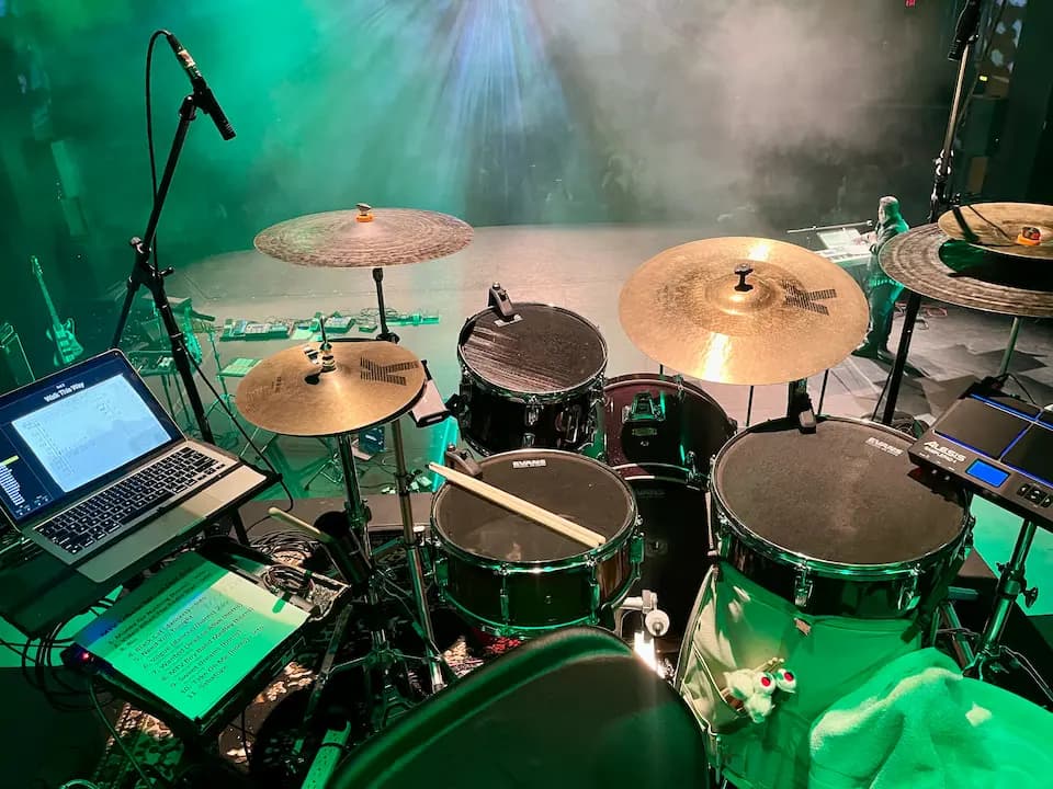 a photo taken from behind the kit showing a stage with green lights and fog