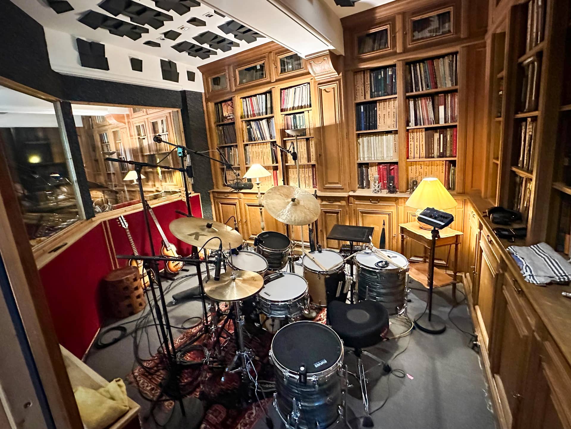 A photo of a drum set in a recording studio.