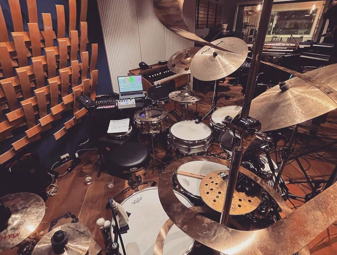 A side profile shot of Wout's setup, showing his lap top and pianos in the studio in the background