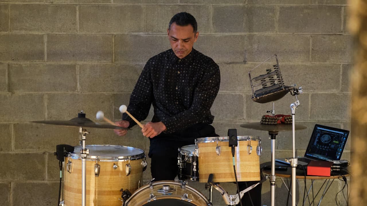 A photo of Hisham Bharoocha playing drums with Sensory Percussion
