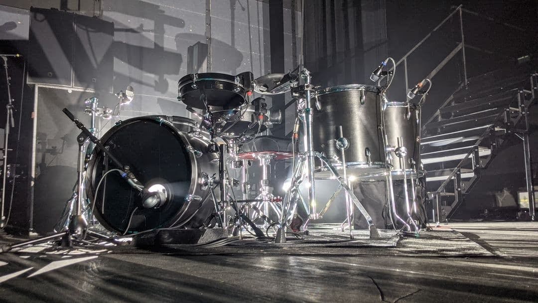 A photo of a black drum kit with Sensory Percussion sensors set up before a live show