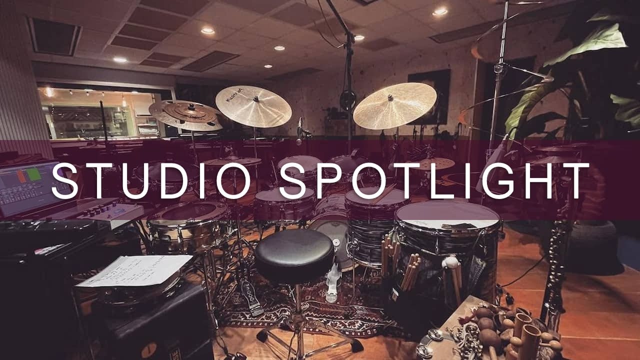 A photo of a live room in a professional recording studio with a drum set set up in the middle
